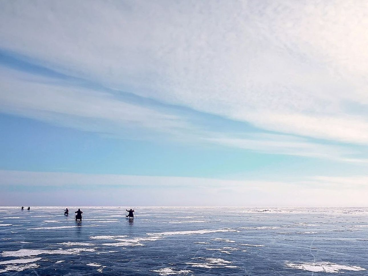 Equipos de pesca en hielo listos en la orilla del lago bajo el hielo