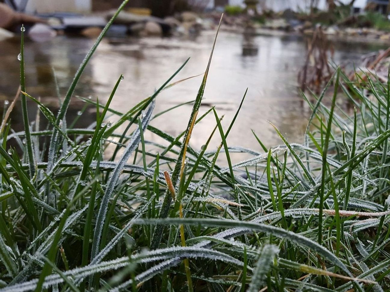 Pescadores en la orilla del lago en montañas cubiertas de nieve